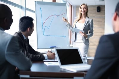 businesswoman showing graphs to team